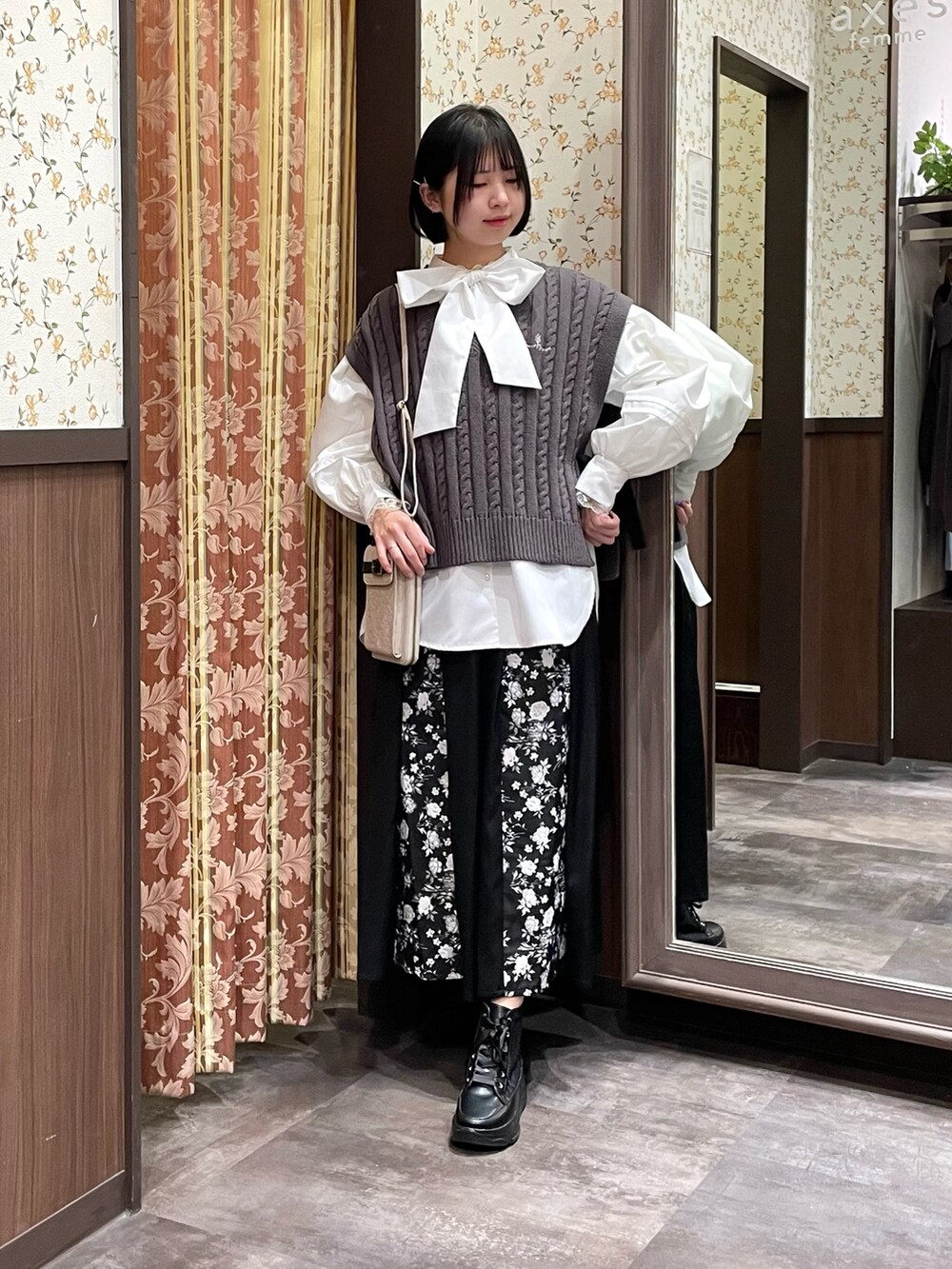 ホワイト系のシャツ/ブラウス、ブラック系のスカート、ブラック系のスニーカーを着用したレディースの春コーディネートの2枚目の写真