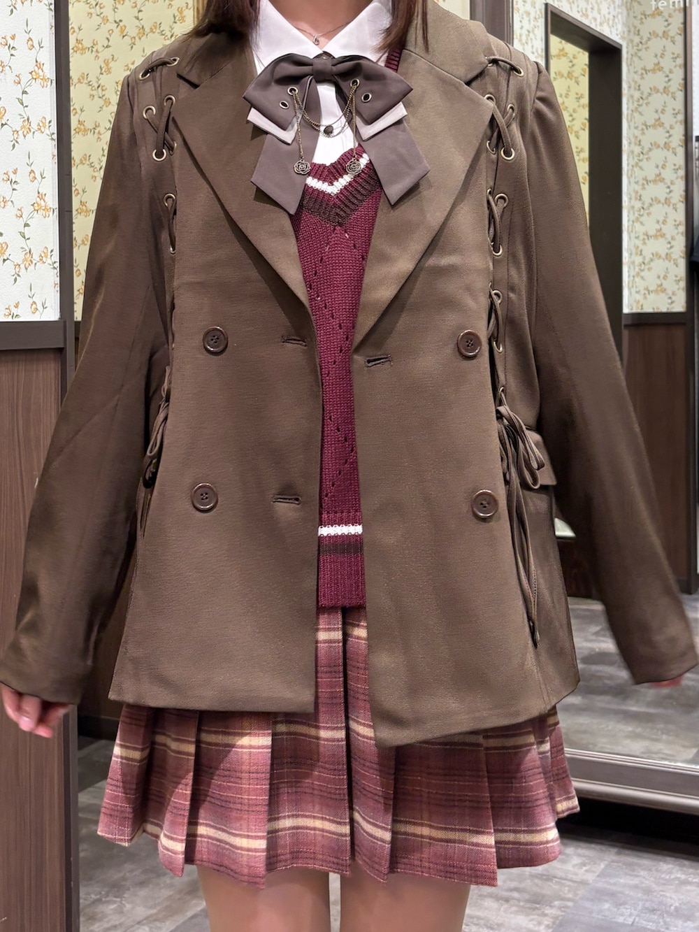レッド系のベスト、ピンク系のその他パンツ、ブラウン系のブーツを着用したレディースの秋コーディネートの5枚目の写真
