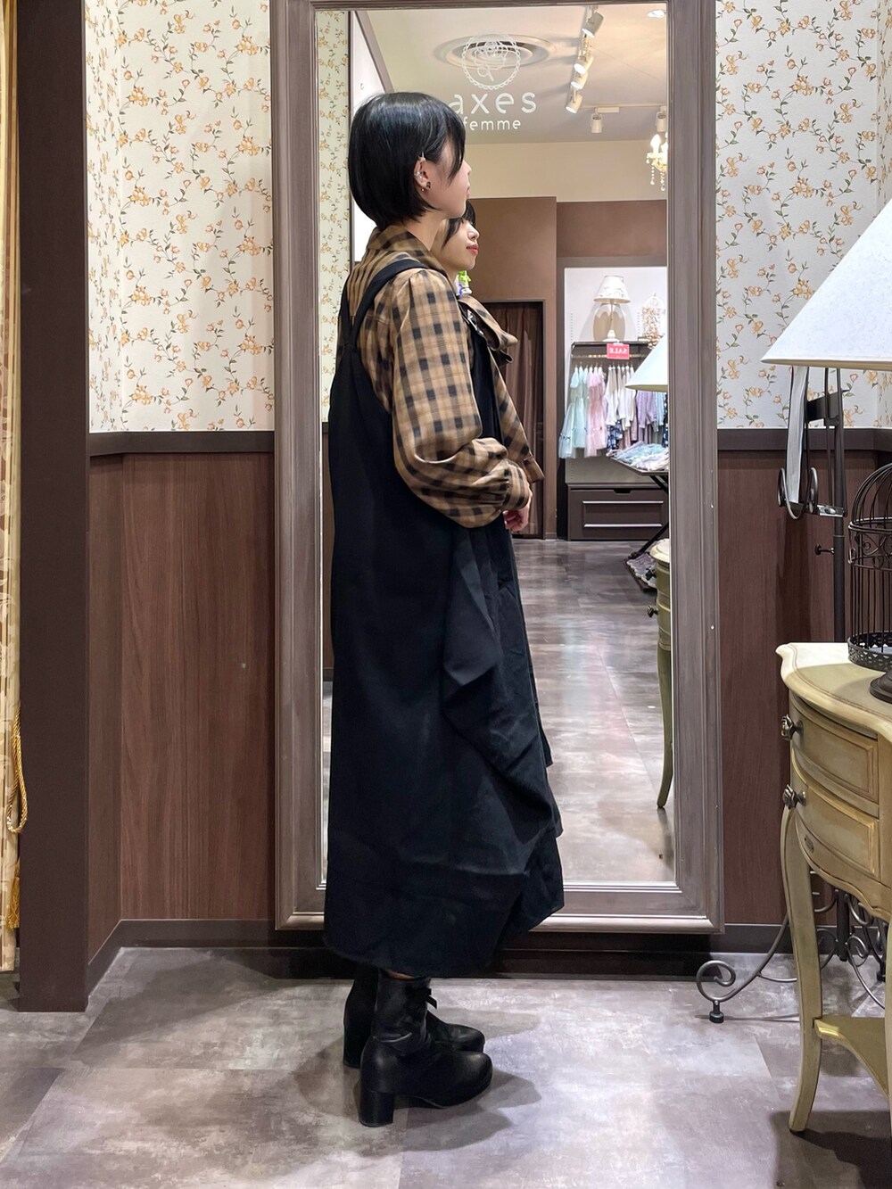 ブラック系のブーツ、ブラック系のジャンパースカート、ブラウン系のシャツ/ブラウスを着用したレディースの秋コーディネートの4枚目の写真