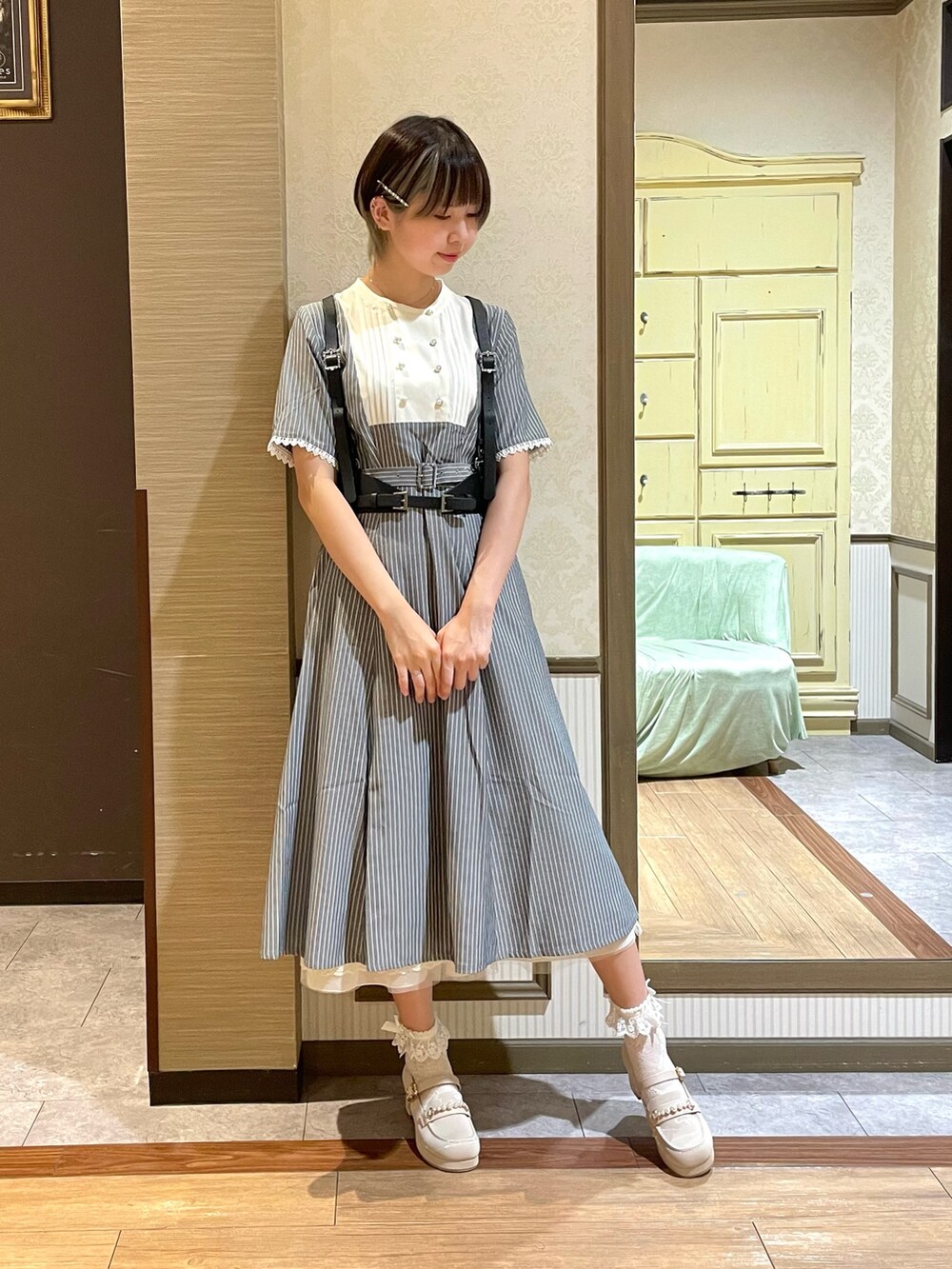 ホワイト系のタンクトップ、ホワイト系のローファー、ブラウン系のショルダーバッグを着用したレディースの夏コーディネートの4枚目の写真