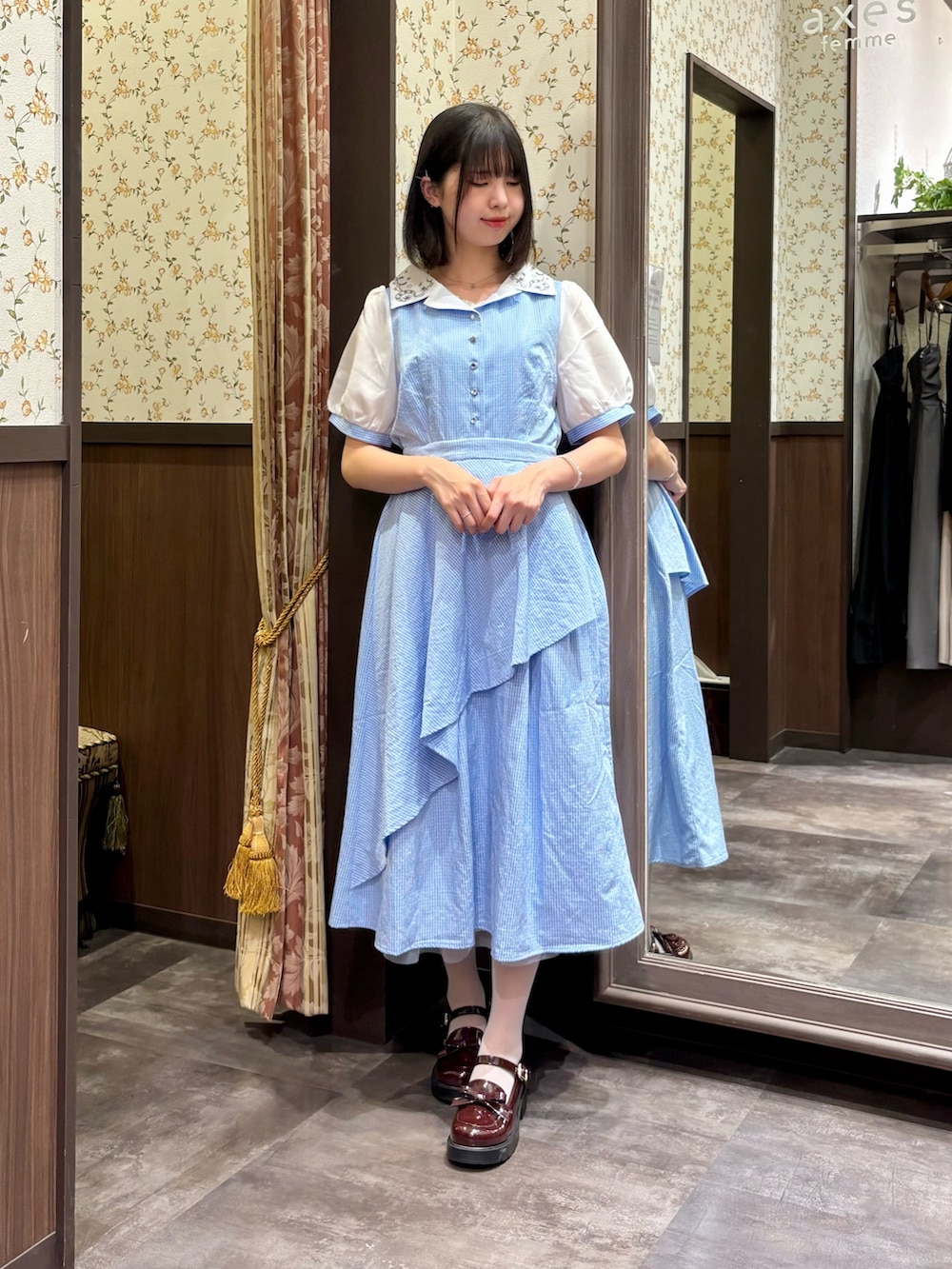 ホワイト系のタンクトップ、ブルー系のワンピース、ブラウン系のボストンバッグを着用したレディースの夏コーディネートの4枚目の写真