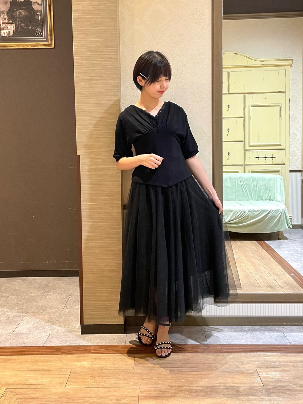 ブラック系のサンダル、ブラック系のスカート、ブラック系のTシャツ/カットソーを着用したレディースの夏コーディネートの3枚目の写真