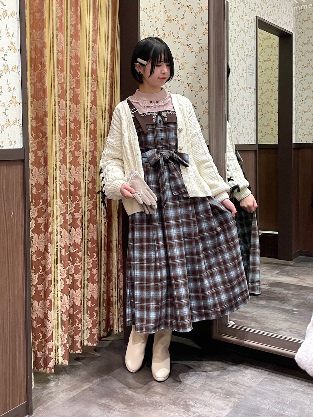 ホワイト系のカーディガン/ボレロ、ブラウン系のジャンパースカート、ピンク系のニット/セーターを着用したレディースの冬コーディネートの7枚目の写真