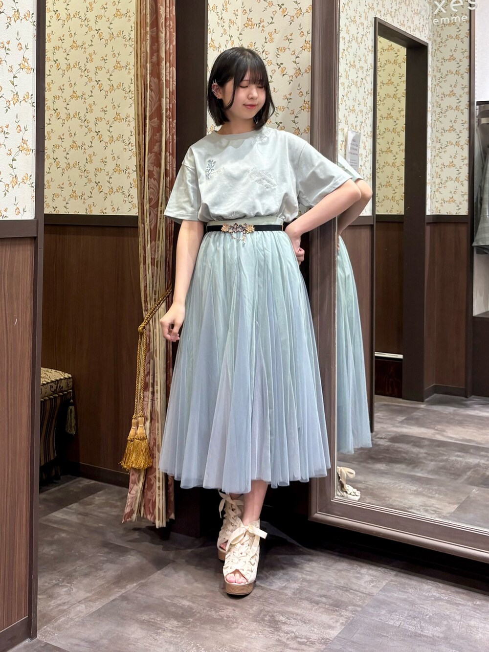 グリーン系のTシャツ/カットソー、グリーン系のスカート、ブルー系のタンクトップを着用したレディースの春コーディネートの6枚目の写真