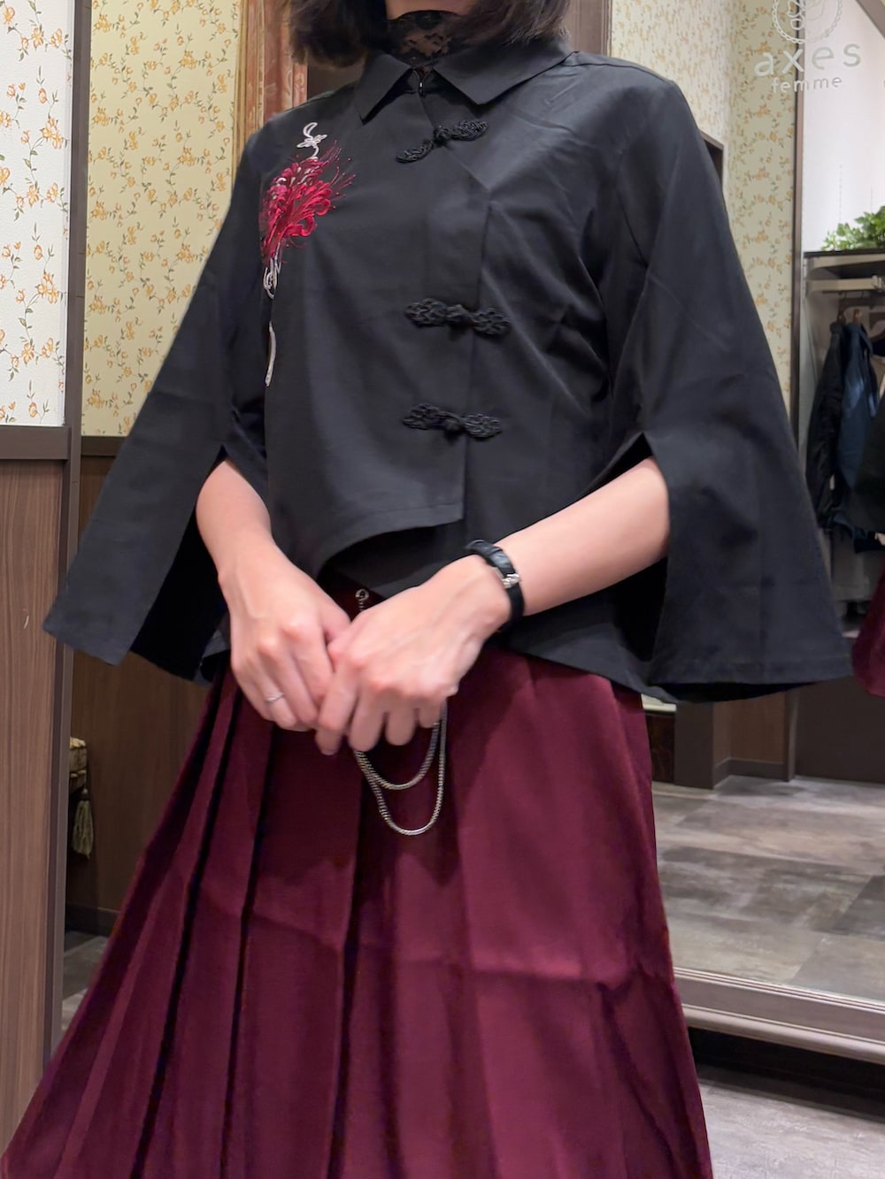 ブラック系のシャツ/ブラウス、ブラック系のTシャツ/カットソー、レッド系のスカートを着用したレディースの夏コーディネートの6枚目の写真