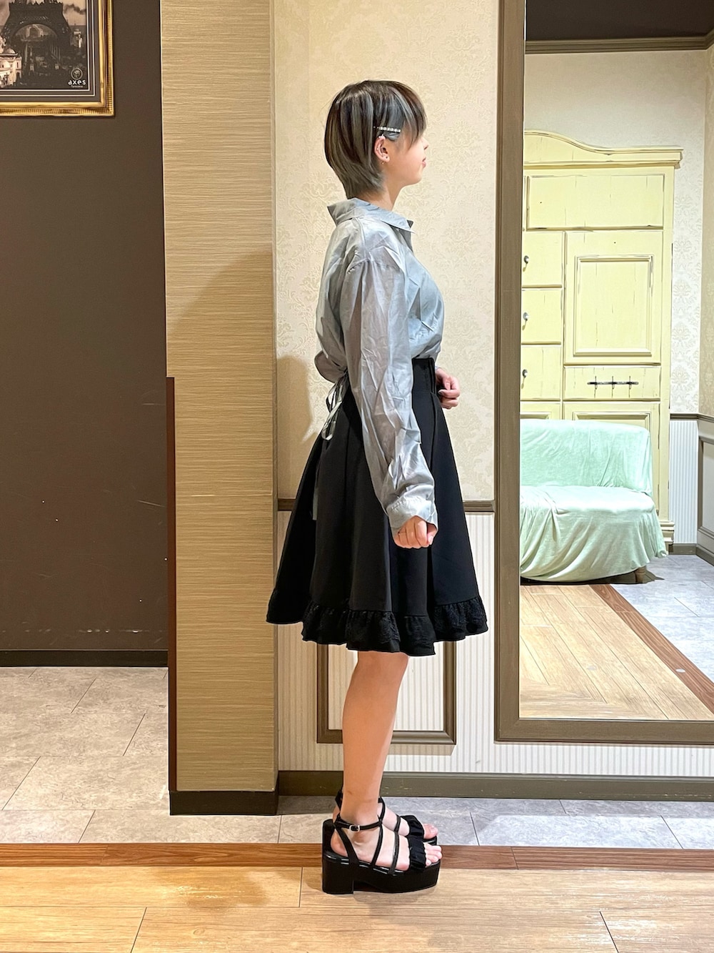 ブラック系のショルダーバッグ、ブラック系のスカート、グリーン系のタンクトップを着用したレディースの夏コーディネートの3枚目の写真