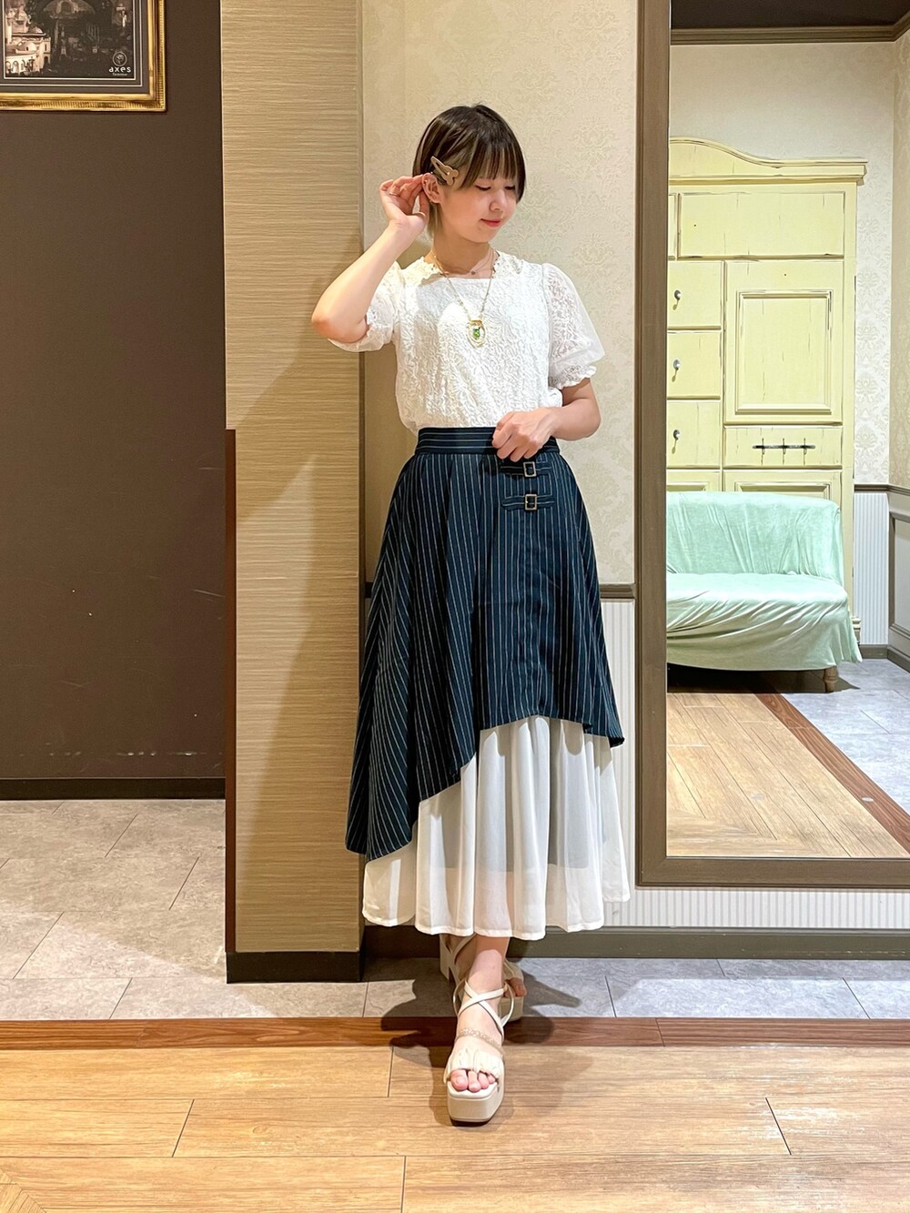 ホワイト系のサンダル、ベージュ系のショルダーバッグ、ホワイト系のタンクトップを着用したレディースの夏コーディネートの3枚目の写真