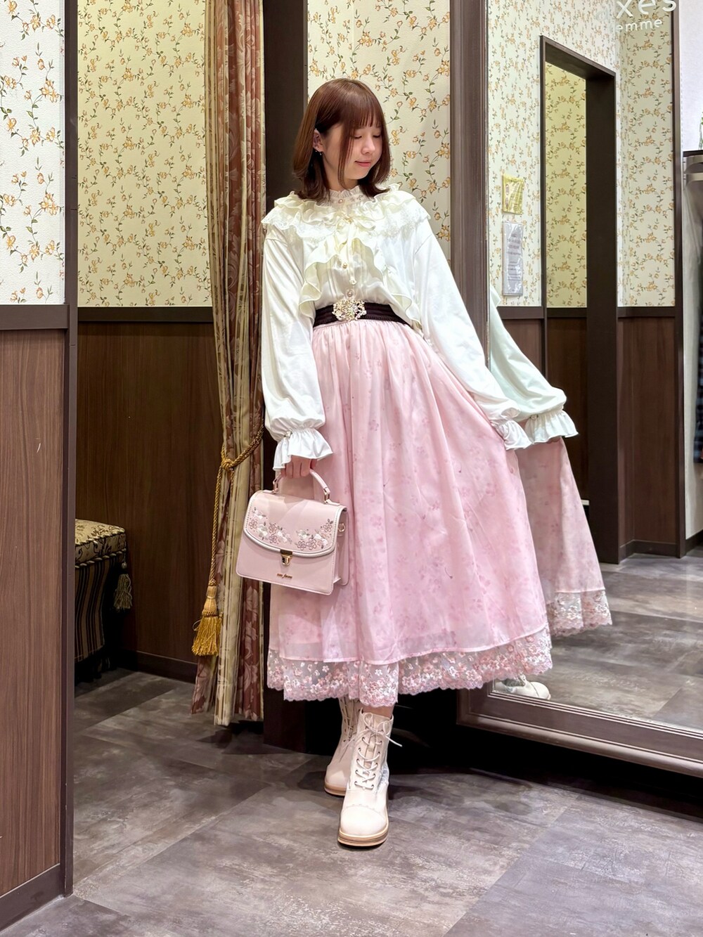 ピンク系のスカート、ベージュ系のブーツ、ピンク系のボストンバッグを着用したレディースの冬コーディネートの2枚目の写真