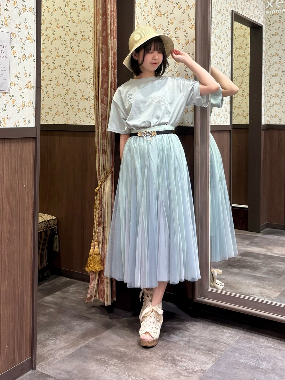 グリーン系のTシャツ/カットソー、グリーン系のスカート、ブルー系のタンクトップを着用したレディースの春コーディネートの3枚目の写真