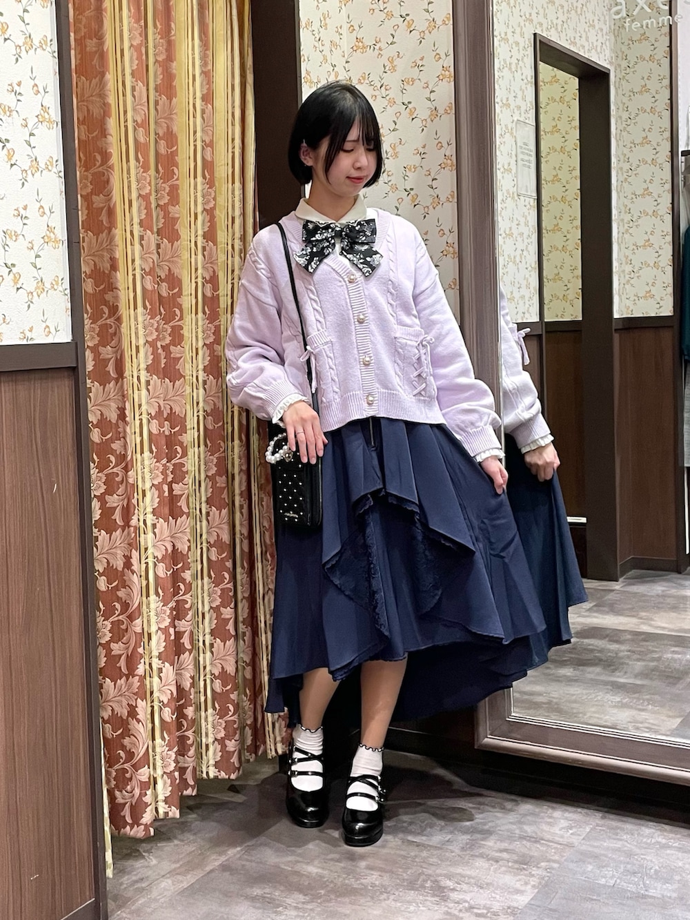 ホワイト系のシャツ/ブラウス、パープル系のカーディガン/ボレロ、ブルー系のスカートを着用したレディースの冬コーディネートの3枚目の写真