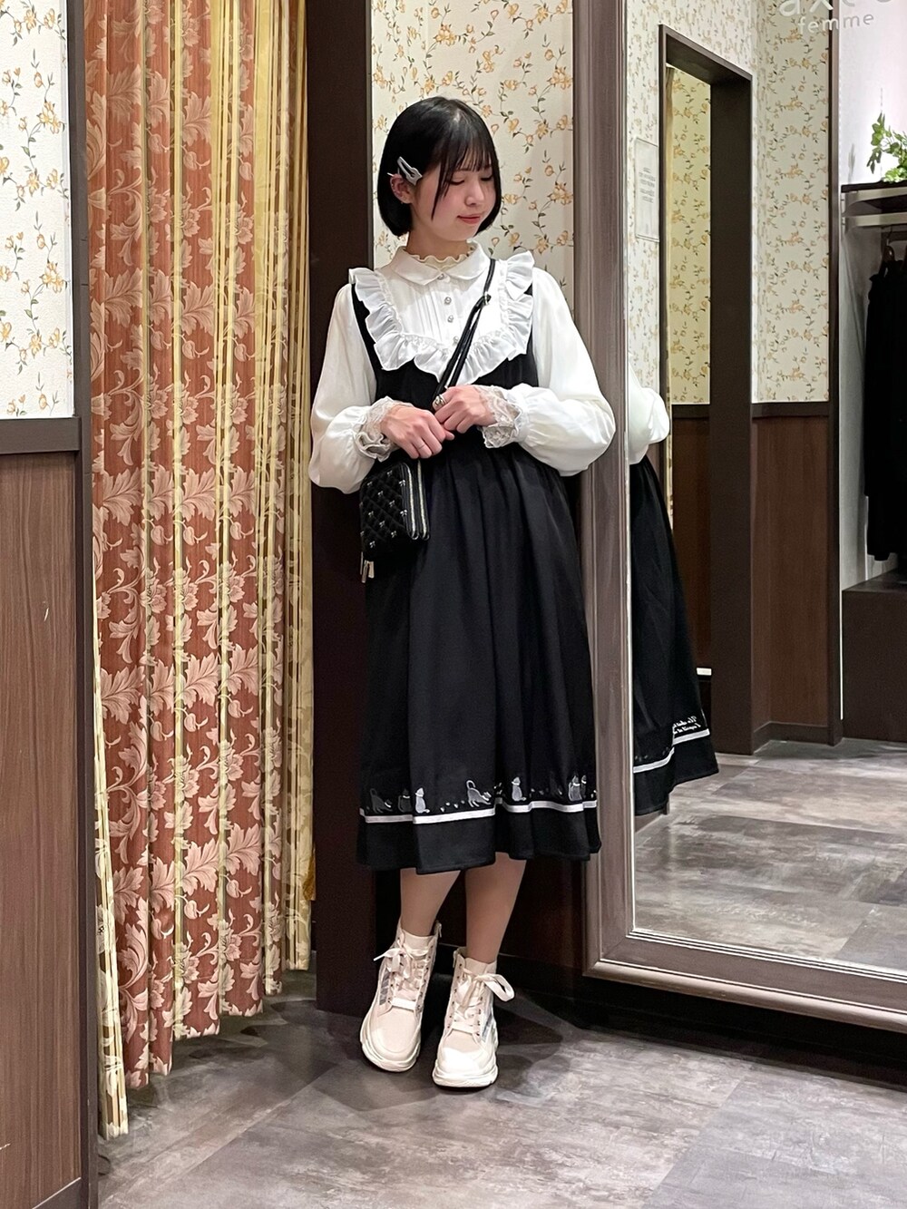 ホワイト系のスニーカー、ブラック系のワンピース、ブラック系のショルダーバッグを着用したレディースの春コーディネートの5枚目の写真