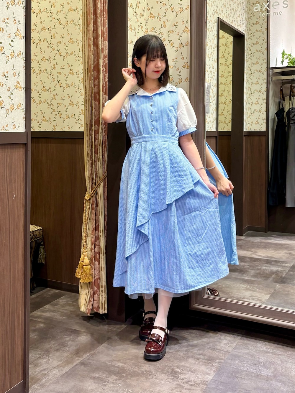 ホワイト系のタンクトップ、ブルー系のワンピース、ブラウン系のボストンバッグを着用したレディースの夏コーディネートの5枚目の写真