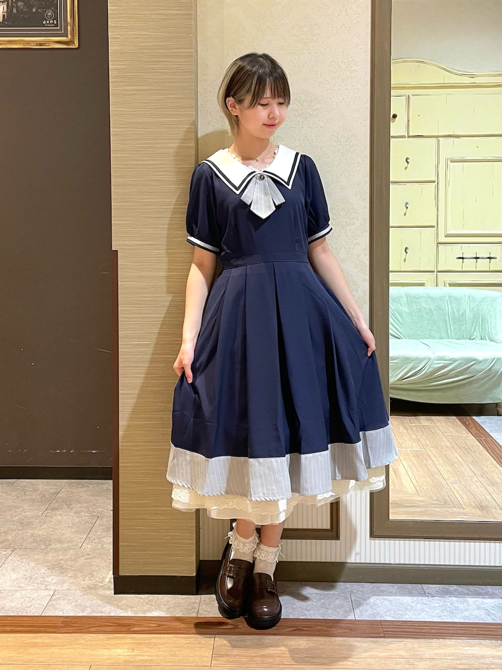 ブラウン系のショルダーバッグ、ホワイト系のタンクトップ、ブラウン系のパンプスを着用したレディースの夏コーディネートの3枚目の写真