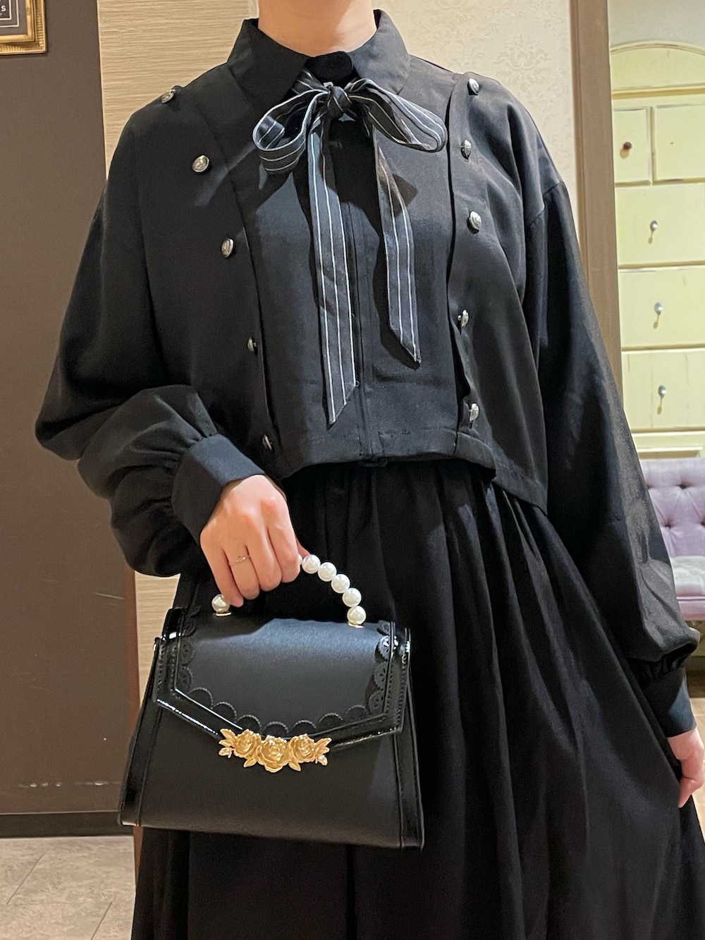 ブラック系のブルゾン、ブラック系のワンピース、ホワイト系のタンクトップを着用したレディースの秋コーディネートの5枚目の写真