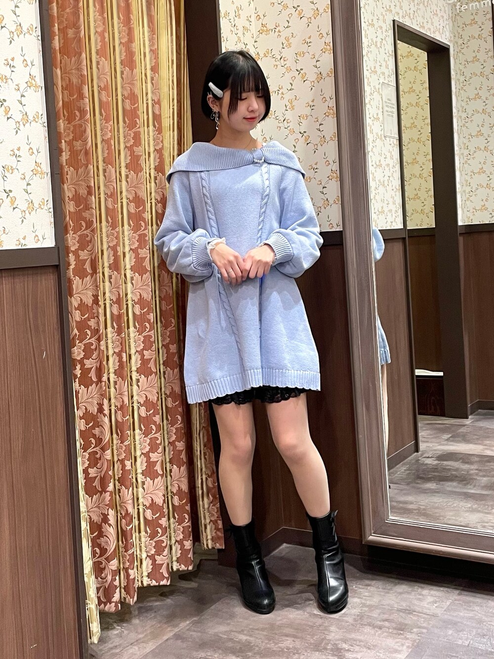 ブルー系のチュニック、ホワイト系のポンチョ、ホワイト系のショルダーバッグを着用したレディースの冬コーディネートの2枚目の写真