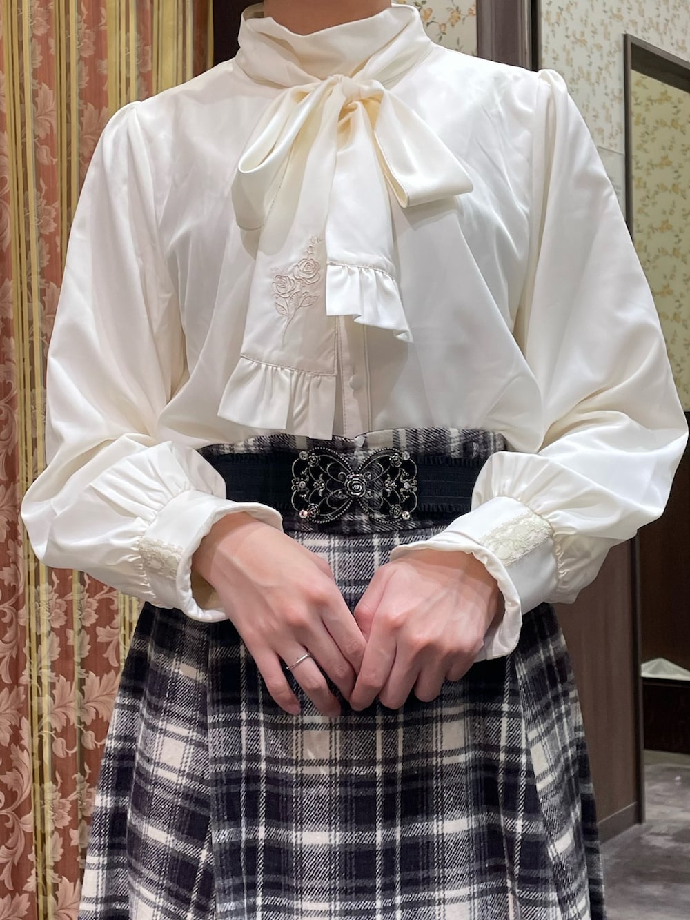 パープル系のスカート、ホワイト系のシャツ/ブラウス、ブラック系のブーツを着用したレディースの冬コーディネートの3枚目の写真