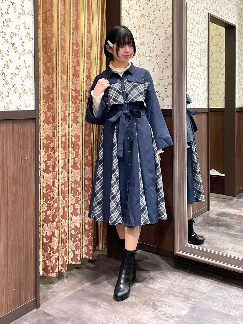 ホワイト系のピーコート、ブルー系のワンピース、ブラック系のブーツを着用したレディースの冬コーディネートの5枚目の写真