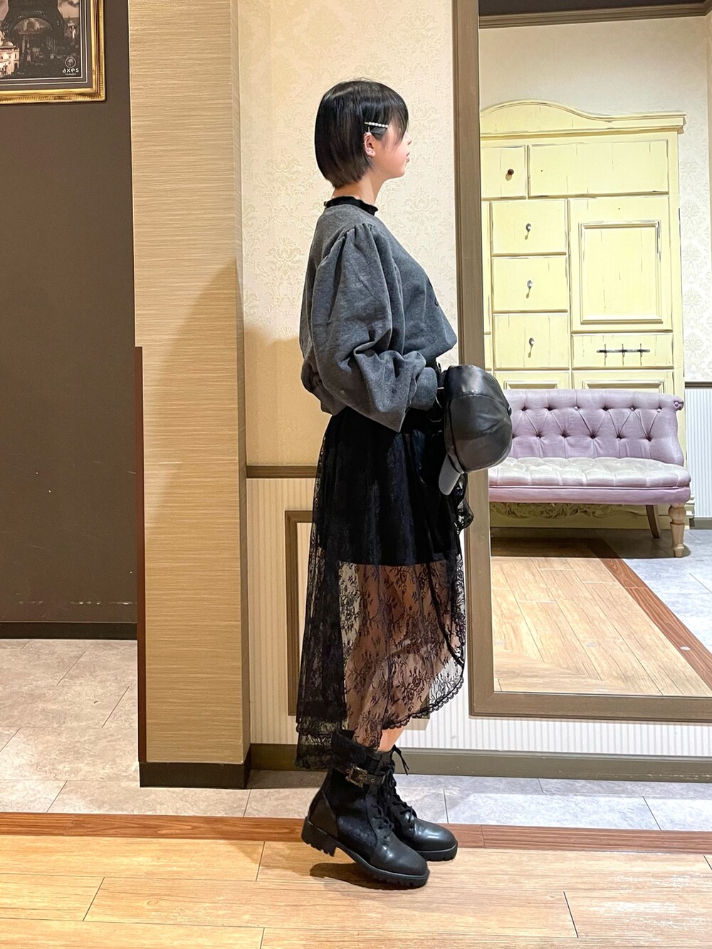 ブラック系のスカート、ブラック系のブーツ、ブラック系のショルダーバッグを着用したレディースの秋コーディネートの3枚目の写真