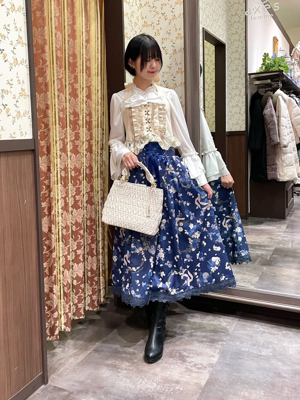 ホワイト系のシャツ/ブラウス、ホワイト系のショルダーバッグ、ブラック系のブーツを着用したレディースの冬コーディネートの3枚目の写真