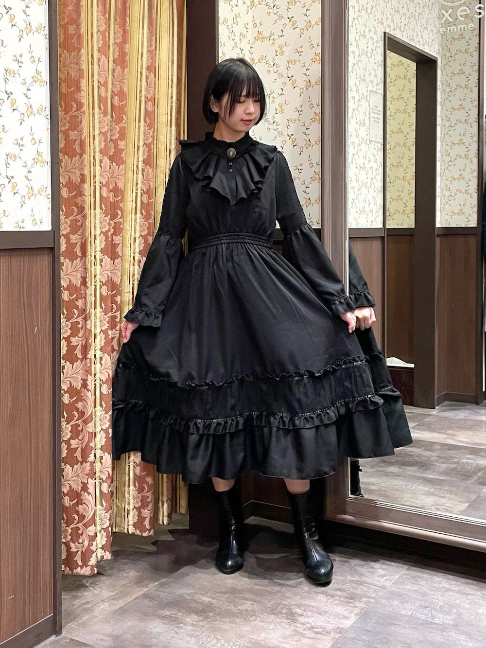 ブラック系のワンピース、ブラック系のブーツ、レッド系のショルダーバッグを着用したレディースの冬コーディネートの5枚目の写真