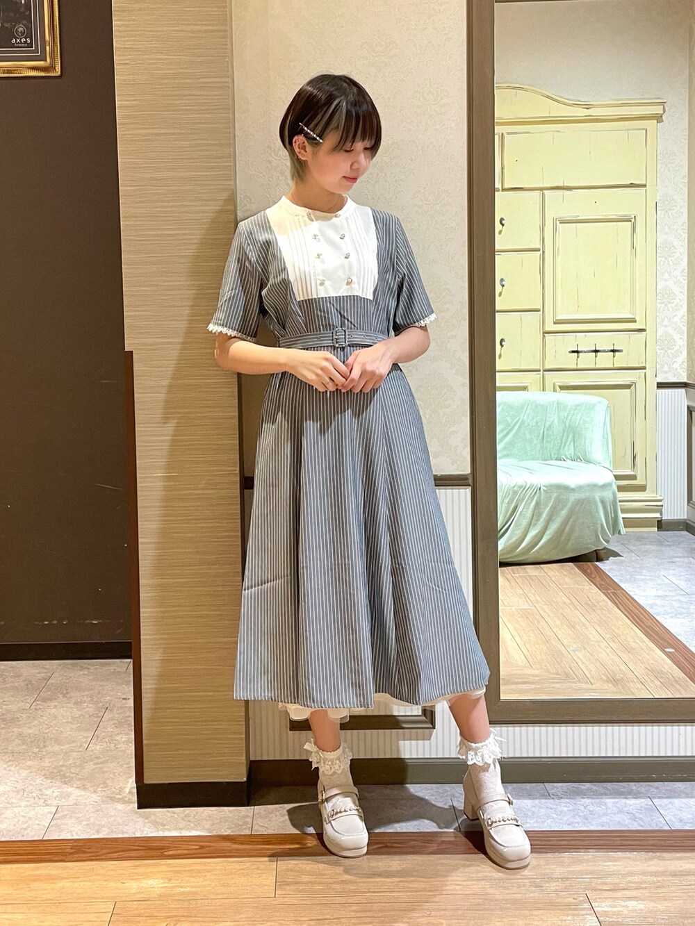 ホワイト系のタンクトップ、ホワイト系のローファー、ブラウン系のショルダーバッグを着用したレディースの夏コーディネートの6枚目の写真