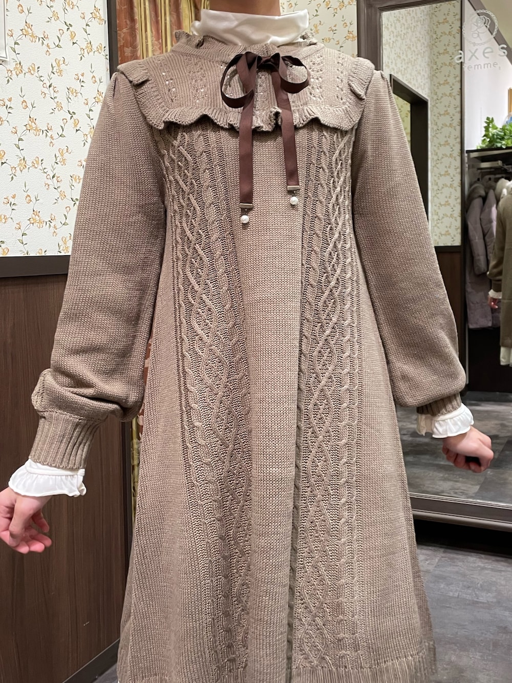 ホワイト系のその他アウター、ブラウン系のワンピース、ブラック系のブーツを着用したレディースの冬コーディネートの7枚目の写真