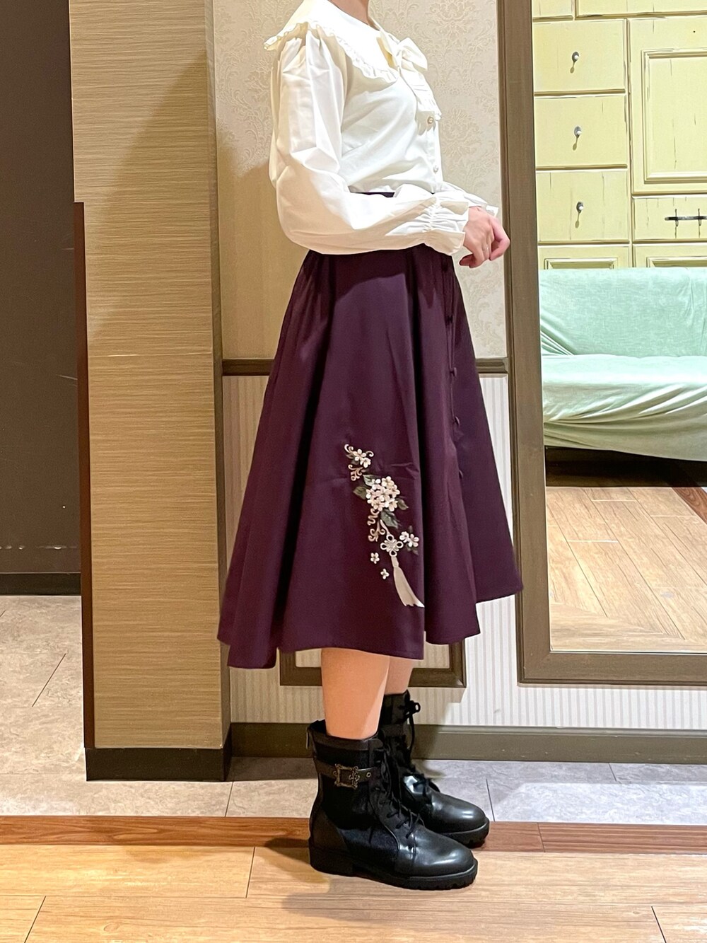 レッド系のスカート、ブラック系のブーツ、ブラック系のショルダーバッグを着用したレディースの秋コーディネートの6枚目の写真