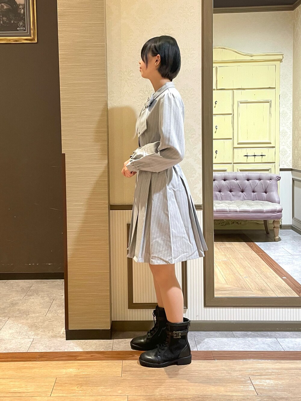 グレー系のワンピース、ブラック系のショルダーバッグ、ブラック系のブーツを着用したレディースの秋コーディネートの6枚目の写真