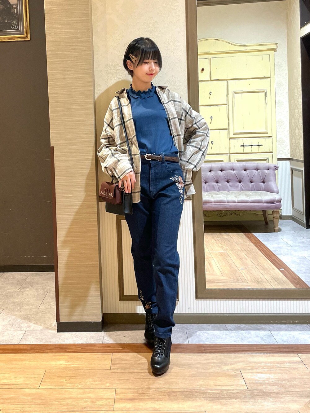 ブルー系のデニムパンツ、ブラック系のブーツ、ブルー系のTシャツ/カットソーを着用したレディースの秋コーディネートの2枚目の写真