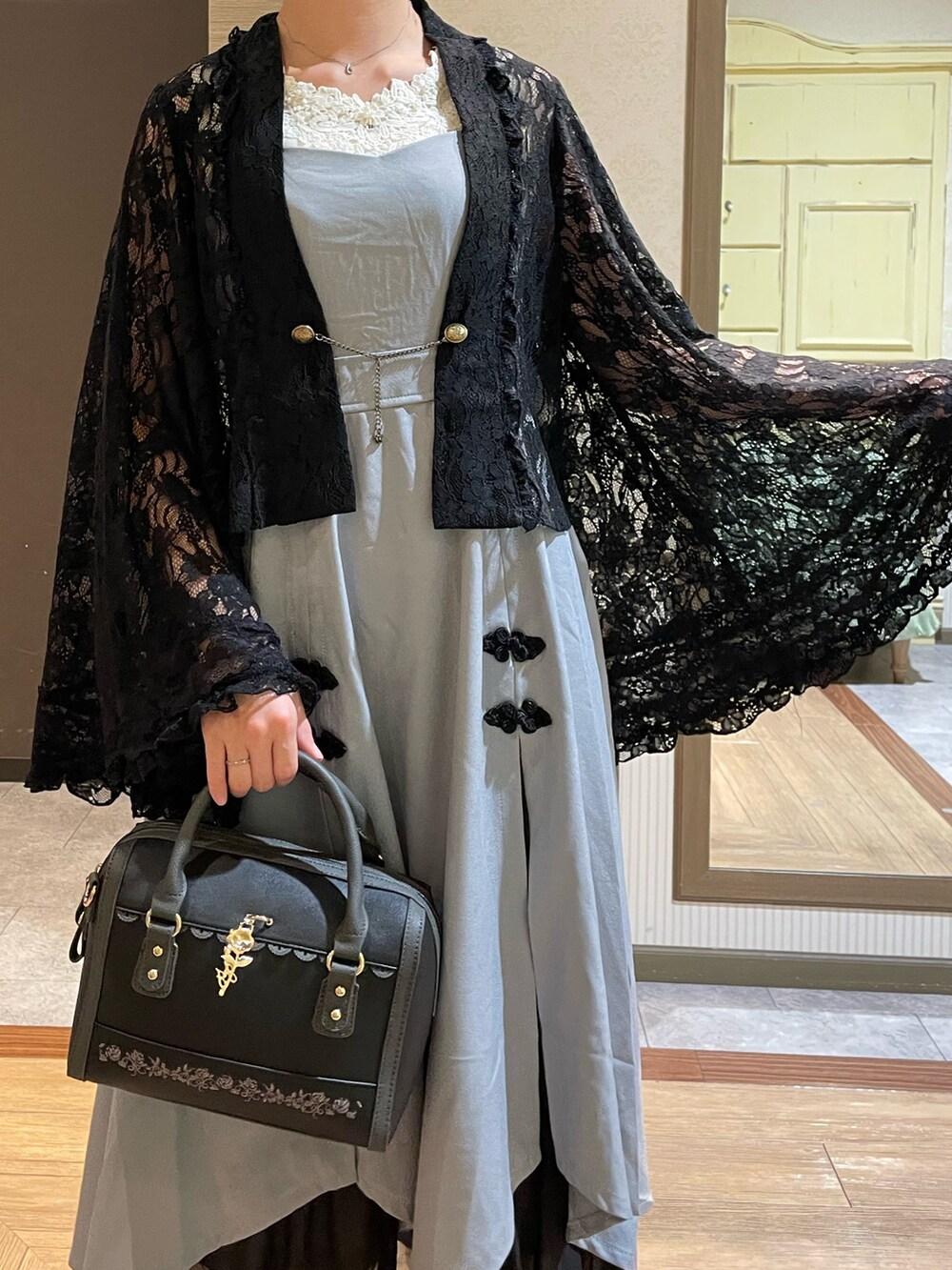 ホワイト系のタンクトップ、ブラック系のブーツ、ブラック系のボストンバッグを着用したレディースの夏コーディネートの3枚目の写真