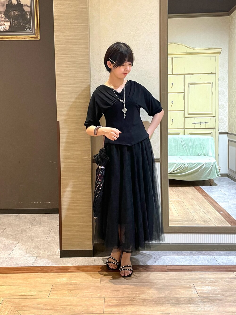 ブラック系のサンダル、ブラック系のスカート、ブラック系のTシャツ/カットソーを着用したレディースの夏コーディネートの2枚目の写真