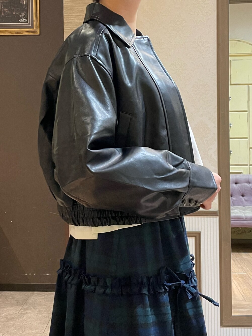 ブラック系のショルダーバッグ、ブラック系のブーツ、グリーン系のスカートを着用したレディースの秋コーディネートの6枚目の写真