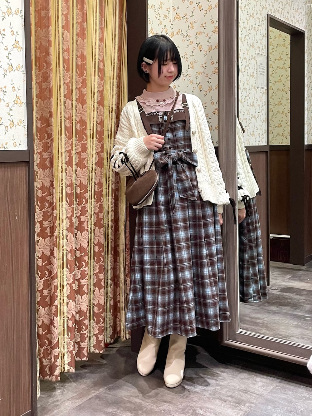 ホワイト系のカーディガン/ボレロ、ブラウン系のジャンパースカート、ピンク系のニット/セーターを着用したレディースの冬コーディネートの3枚目の写真