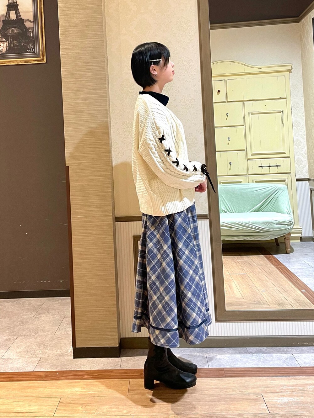 ブラック系のブーツ、ホワイト系のカーディガン/ボレロ、ブルー系のスカートを着用したレディースの秋コーディネートの5枚目の写真