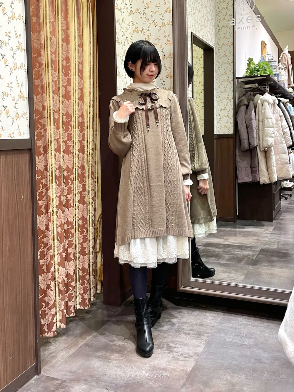 ホワイト系のその他アウター、ブラウン系のワンピース、ブラック系のブーツを着用したレディースの冬コーディネートの5枚目の写真