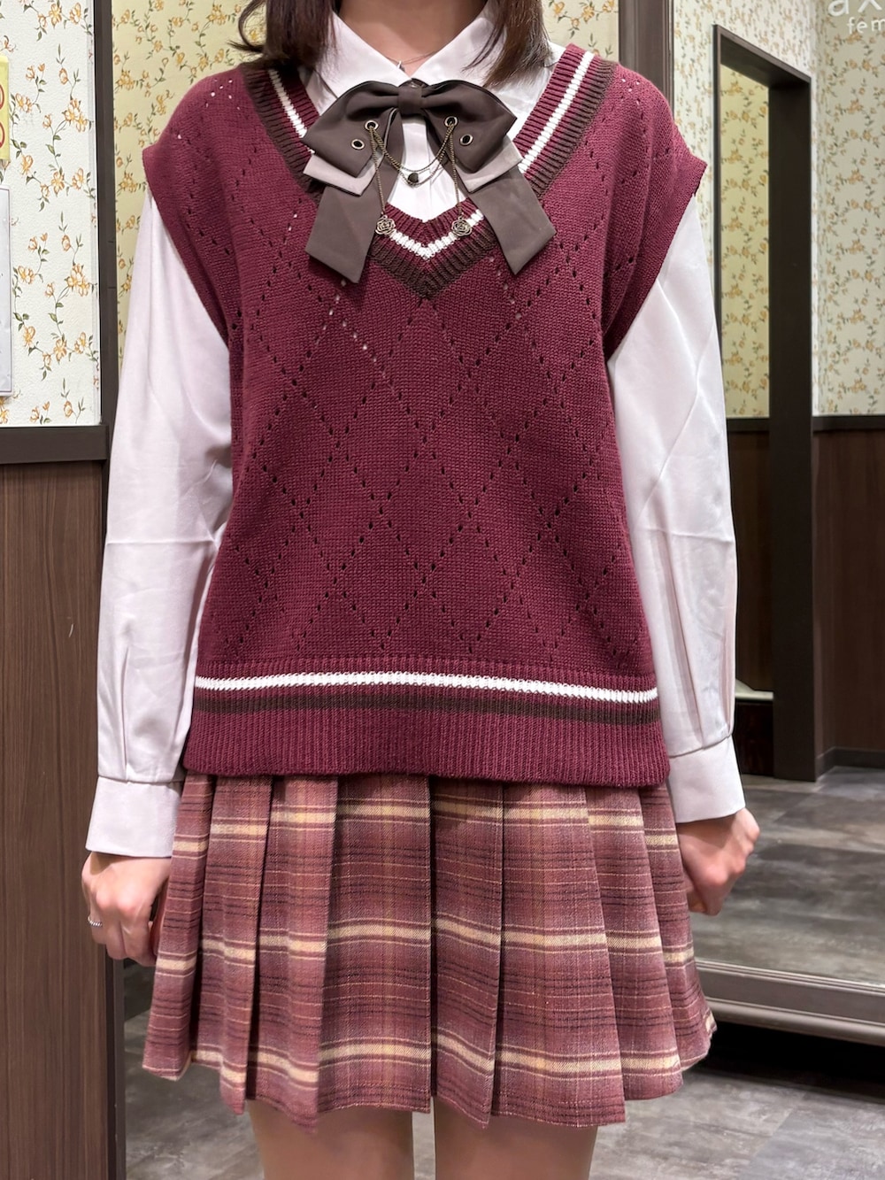 レッド系のベスト、ピンク系のその他パンツ、ブラウン系のブーツを着用したレディースの秋コーディネートの10枚目の写真