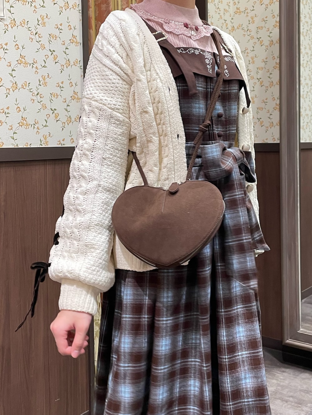 ホワイト系のカーディガン/ボレロ、ブラウン系のジャンパースカート、ピンク系のニット/セーターを着用したレディースの冬コーディネートの4枚目の写真