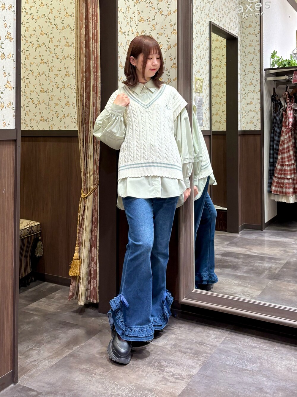グリーン系のシャツ/ブラウス、ホワイト系のベスト、グリーン系のボストンバッグを着用したレディースの冬コーディネートの7枚目の写真