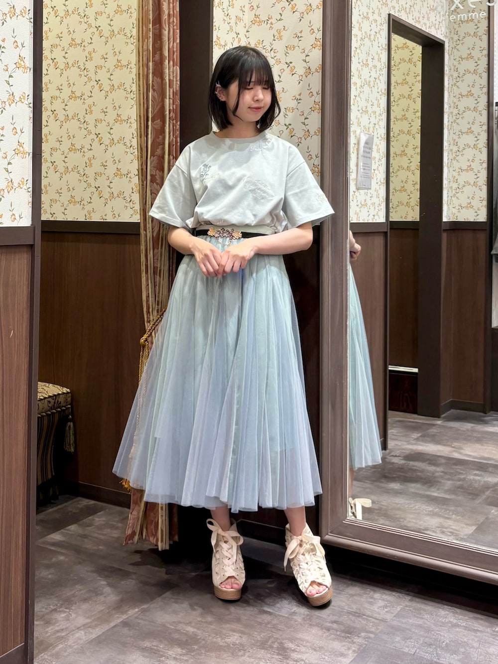 グリーン系のTシャツ/カットソー、グリーン系のスカート、ブルー系のタンクトップを着用したレディースの春コーディネートの5枚目の写真