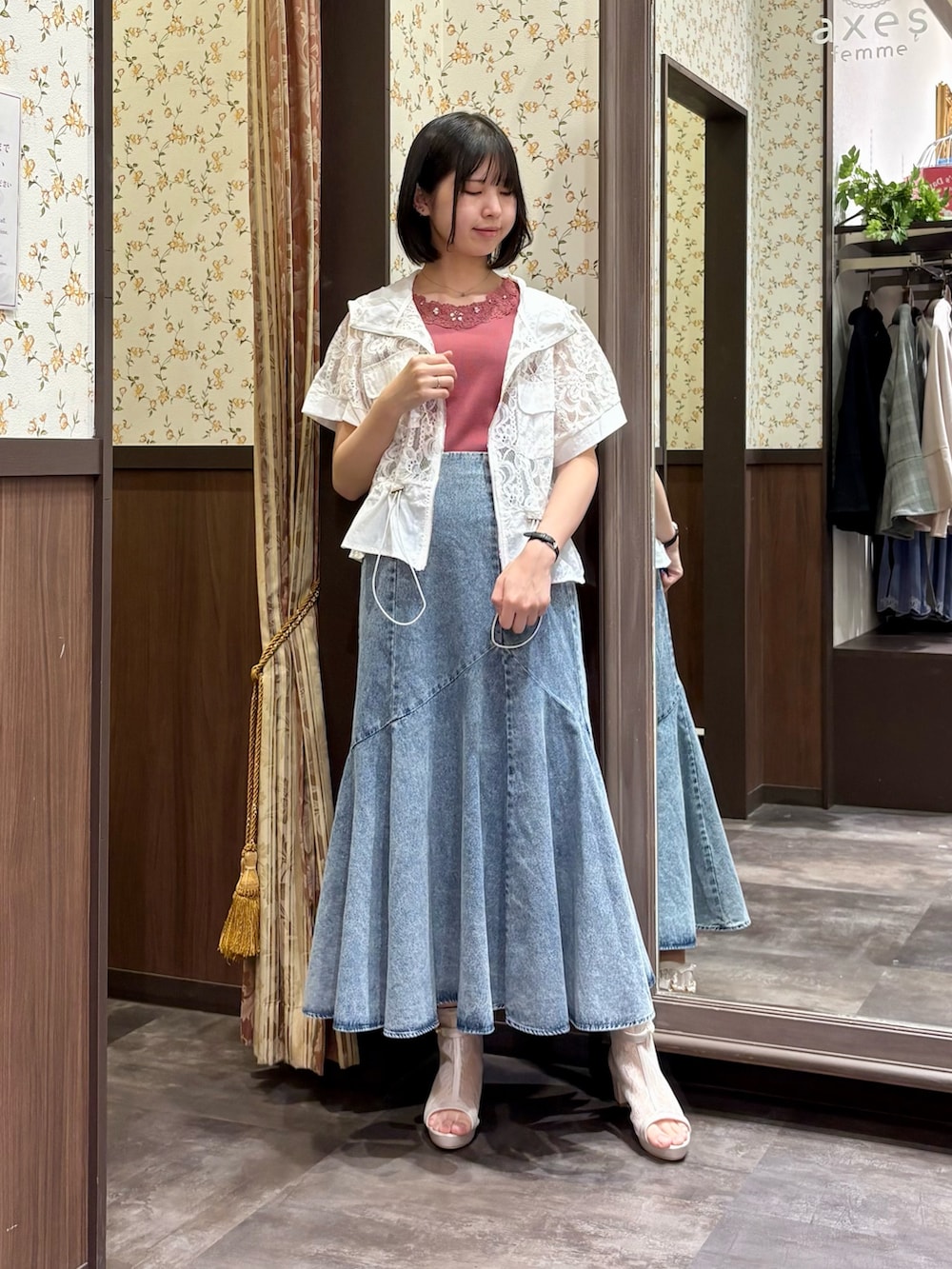 ホワイト系のカーディガン/ボレロ、レッド系のタンクトップ、ブルー系のデニムスカートを着用したレディースの春コーディネートの4枚目の写真