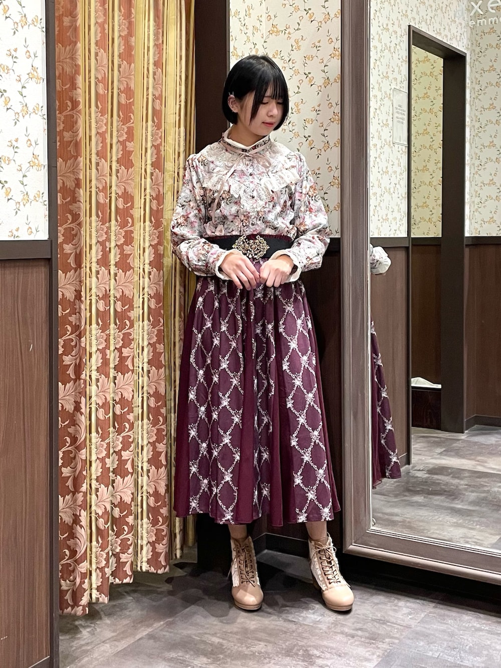 ホワイト系のカーディガン/ボレロ、グリーン系のシャツ/ブラウス、レッド系のスカートを着用したレディースの冬コーディネートの5枚目の写真