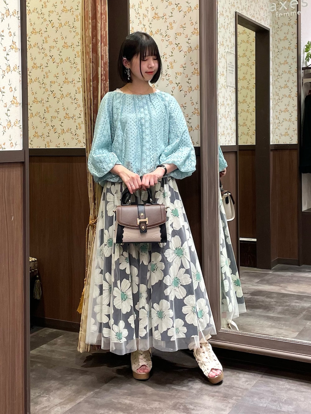 ホワイト系のタンクトップ、グリーン系のTシャツ/カットソー、ブラウン系のショルダーバッグを着用したレディースの春コーディネートの2枚目の写真