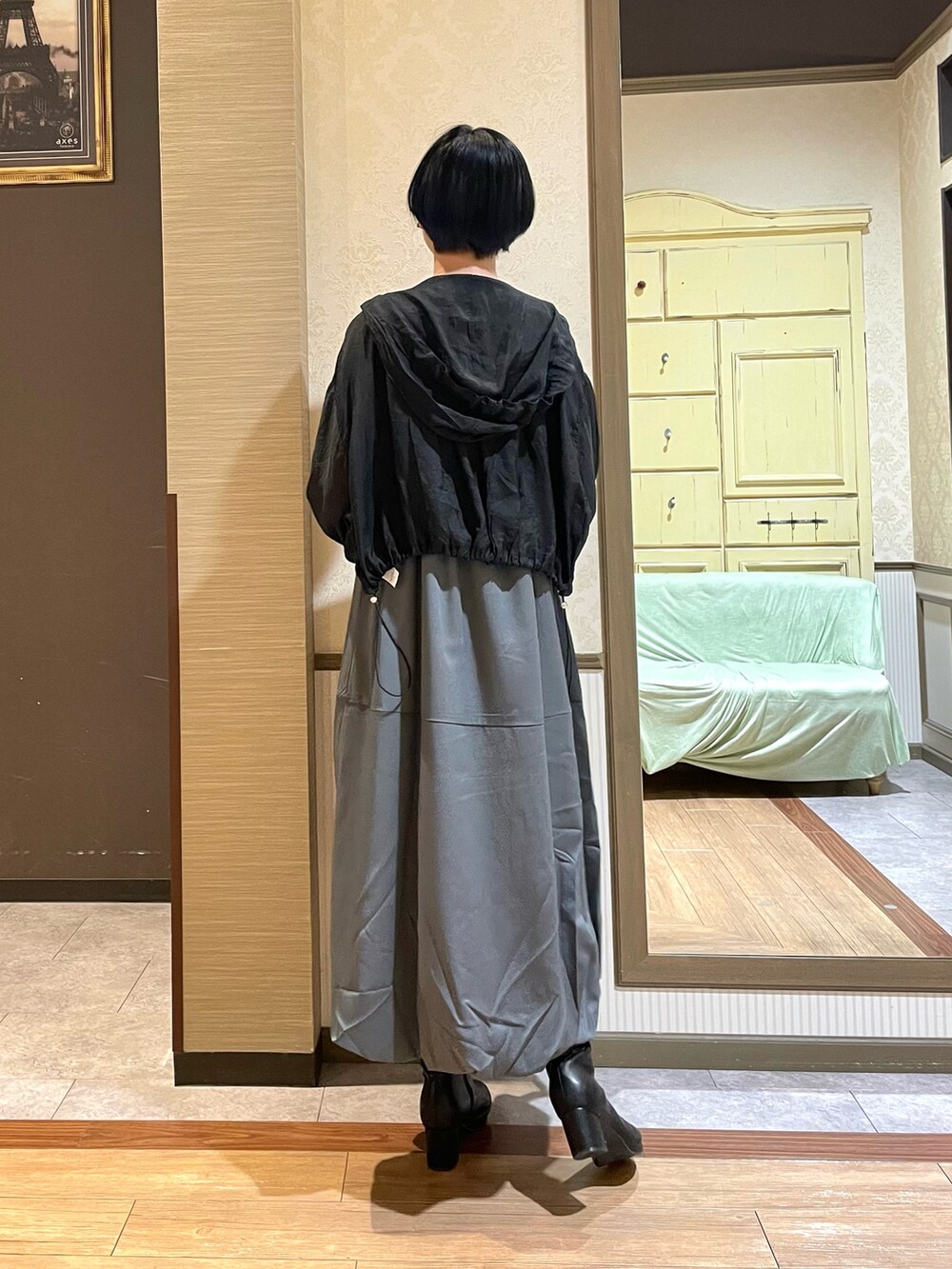 ブラック系のブルゾン、ブラック系のタンクトップ、グレー系のジャンパースカートを着用したレディースの秋コーディネートの6枚目の写真