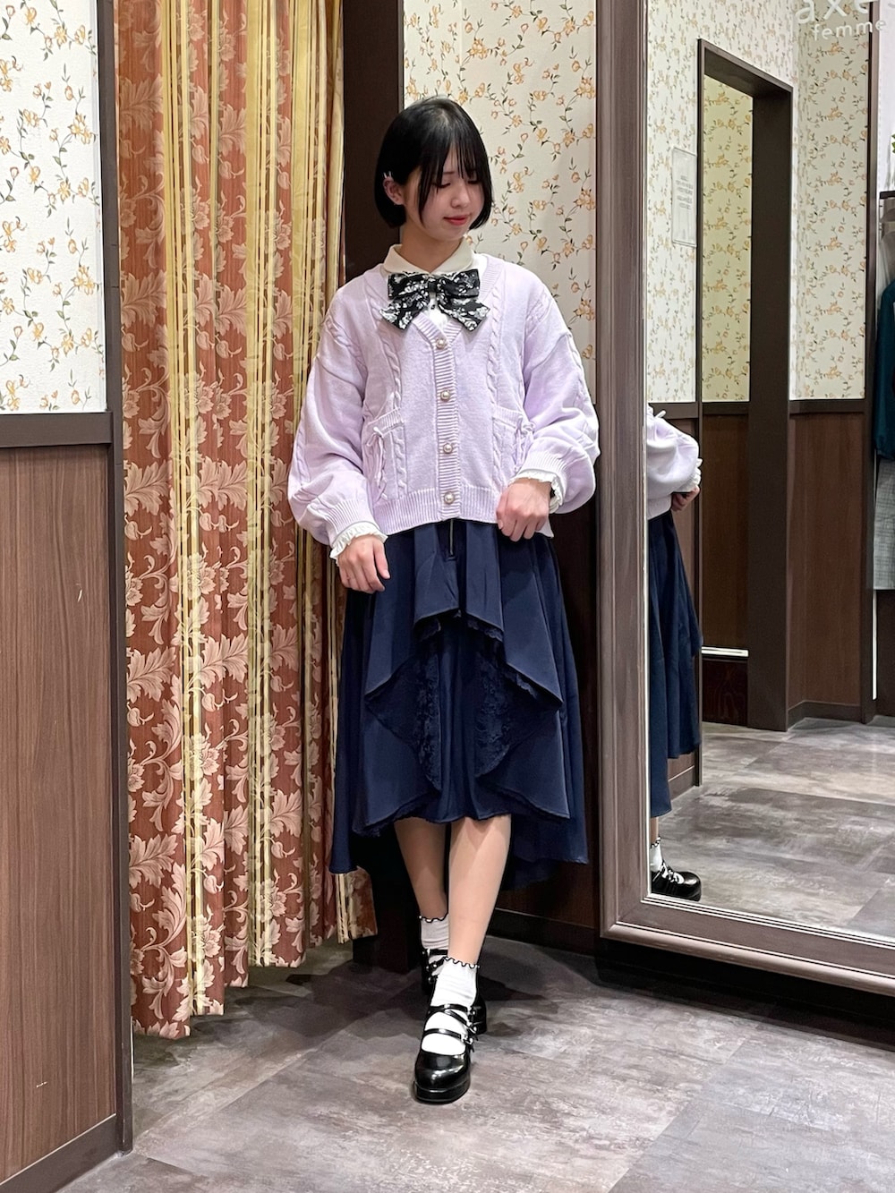 ホワイト系のシャツ/ブラウス、パープル系のカーディガン/ボレロ、ブルー系のスカートを着用したレディースの冬コーディネートの2枚目の写真