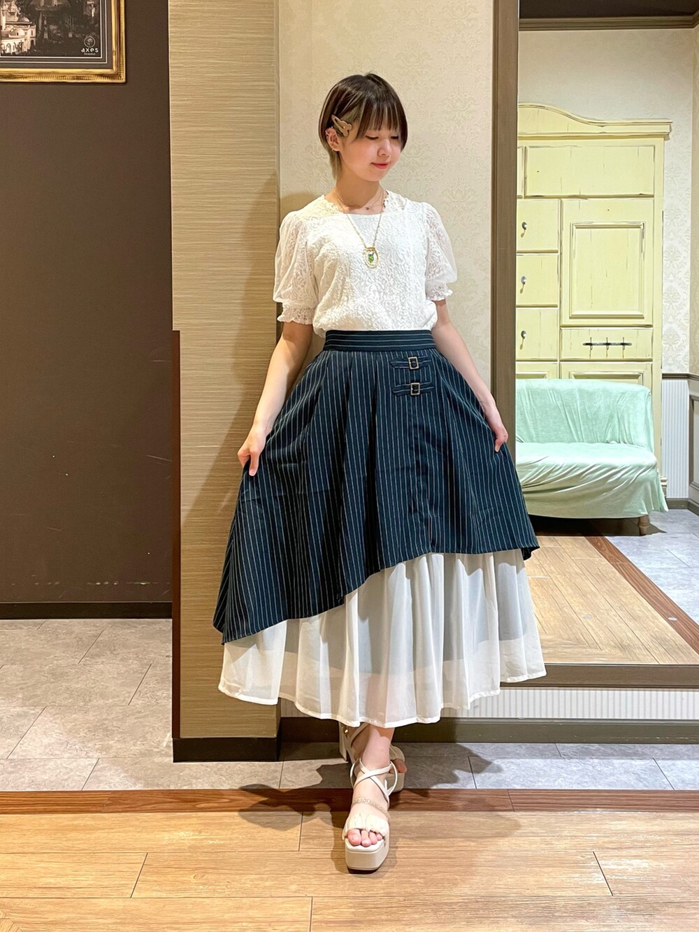 ホワイト系のサンダル、ベージュ系のショルダーバッグ、ホワイト系のタンクトップを着用したレディースの夏コーディネートの4枚目の写真