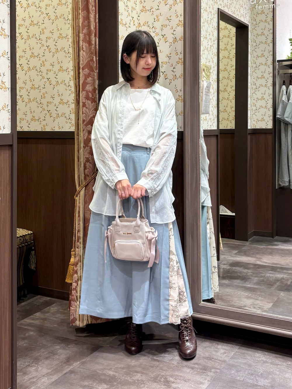 グリーン系のシャツ/ブラウス、ベージュ系のショルダーバッグ、ブラウン系のブーツを着用したレディースの夏コーディネートの7枚目の写真
