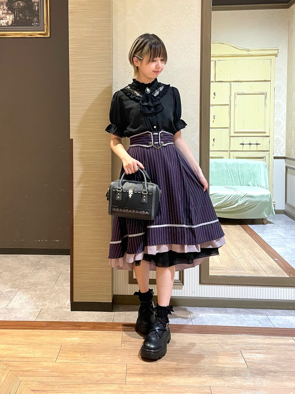 ホワイト系のタンクトップ、ブラック系のパンプス、ブラック系のボストンバッグを着用したレディースの夏コーディネートの5枚目の写真