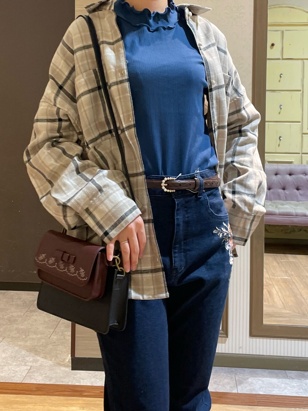 ブルー系のデニムパンツ、ブラック系のブーツ、ブルー系のTシャツ/カットソーを着用したレディースの秋コーディネートの5枚目の写真