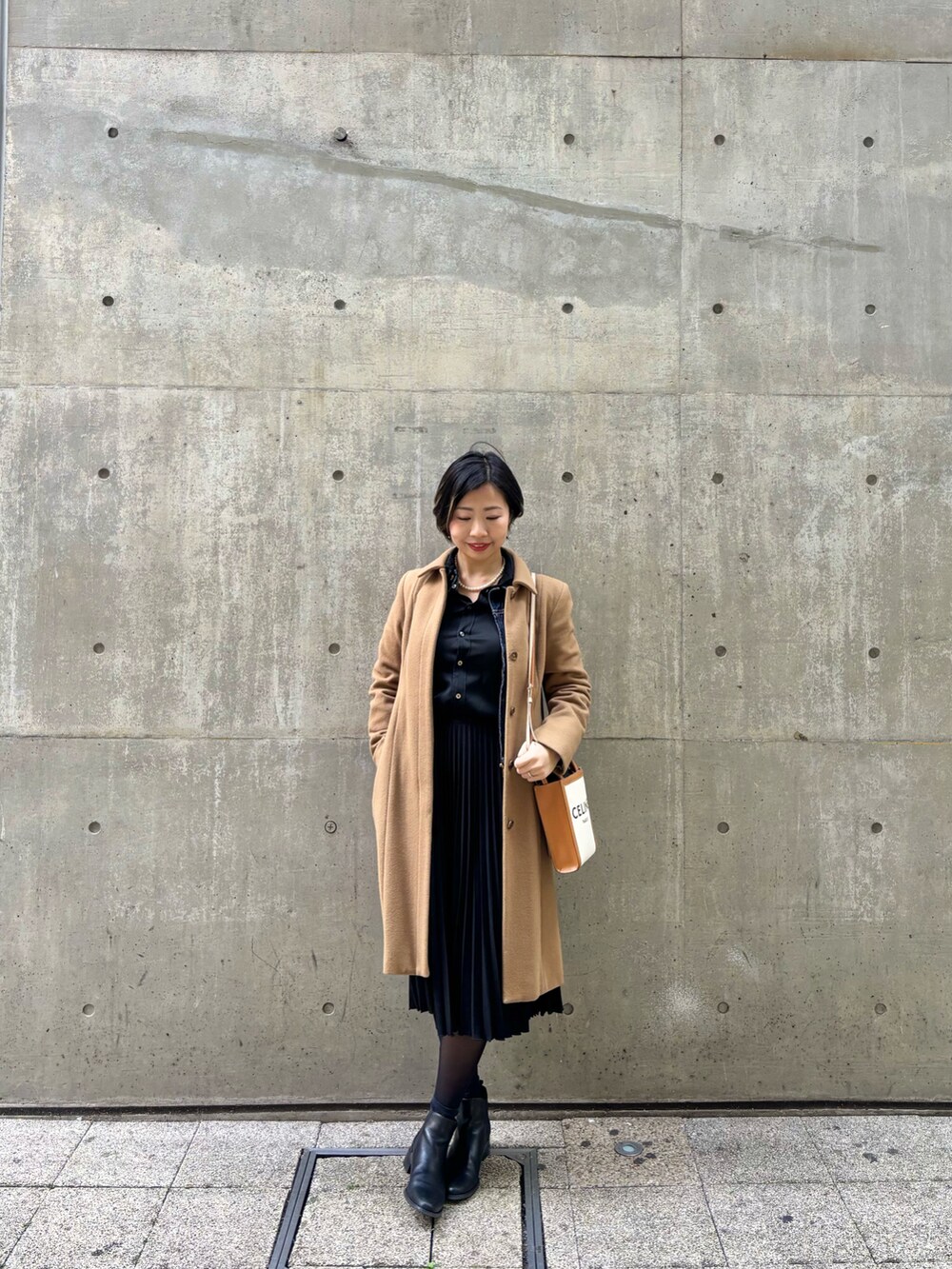 ブラック系のスカート、ブラック系のシャツ/ブラウス、ブラウン系のステンカラーコートを着用したレディースの春コーディネートの2枚目の写真
