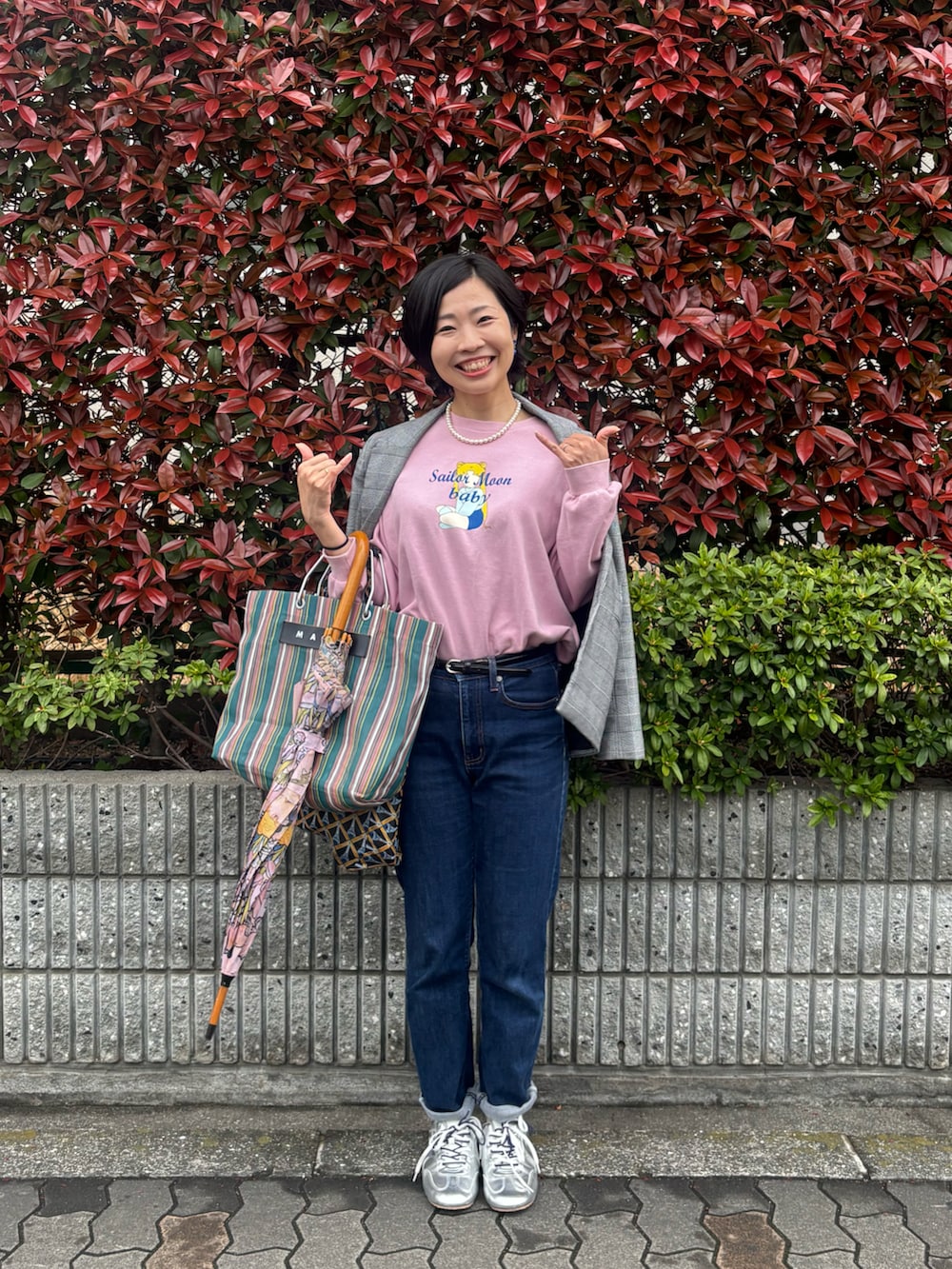 ピンク系のパーカー、グレー系のテーラードジャケット、ブルー系のデニムパンツを着用したレディースの春コーディネートの2枚目の写真